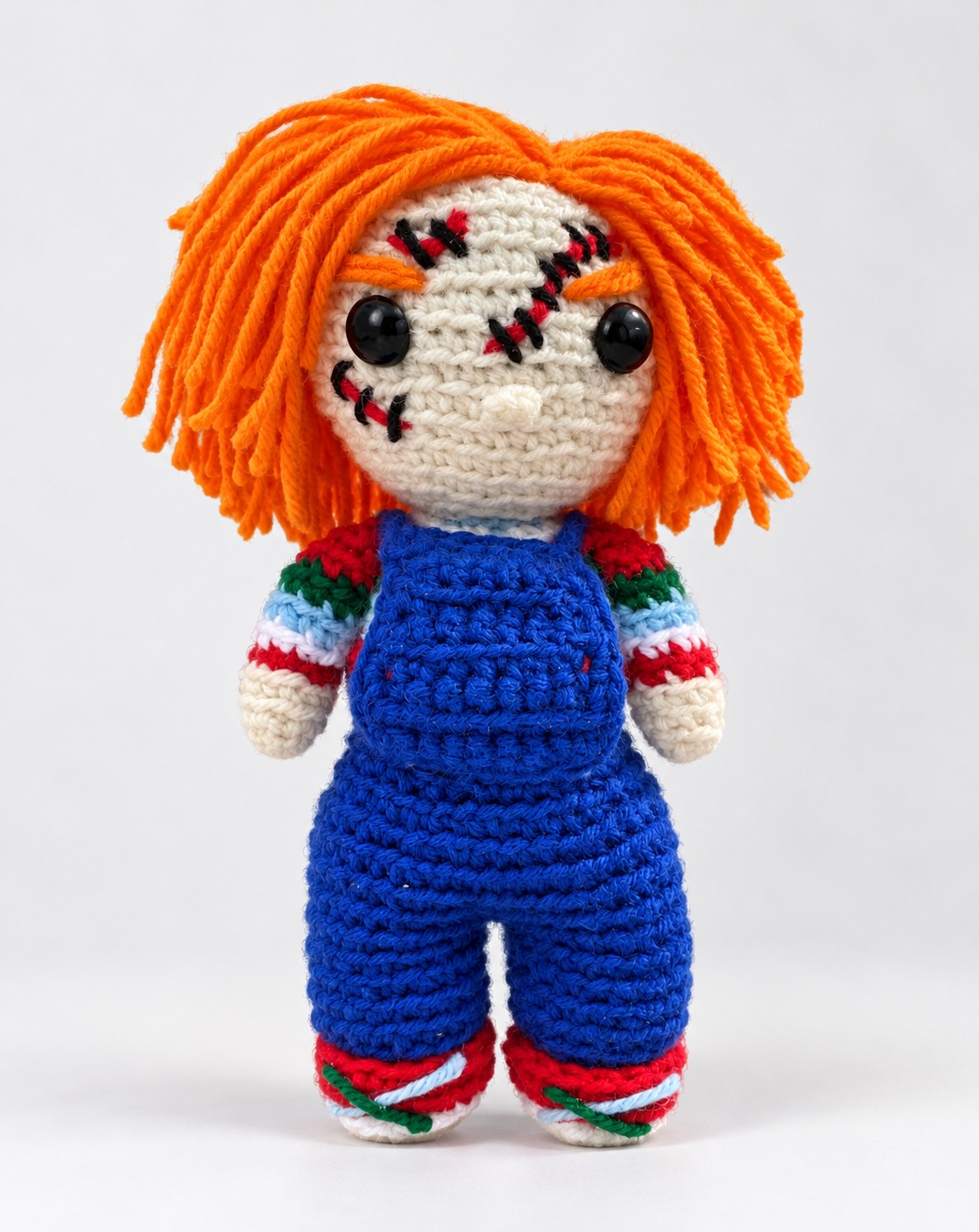 Orange-haired scarred crochet character plushie in blue overalls