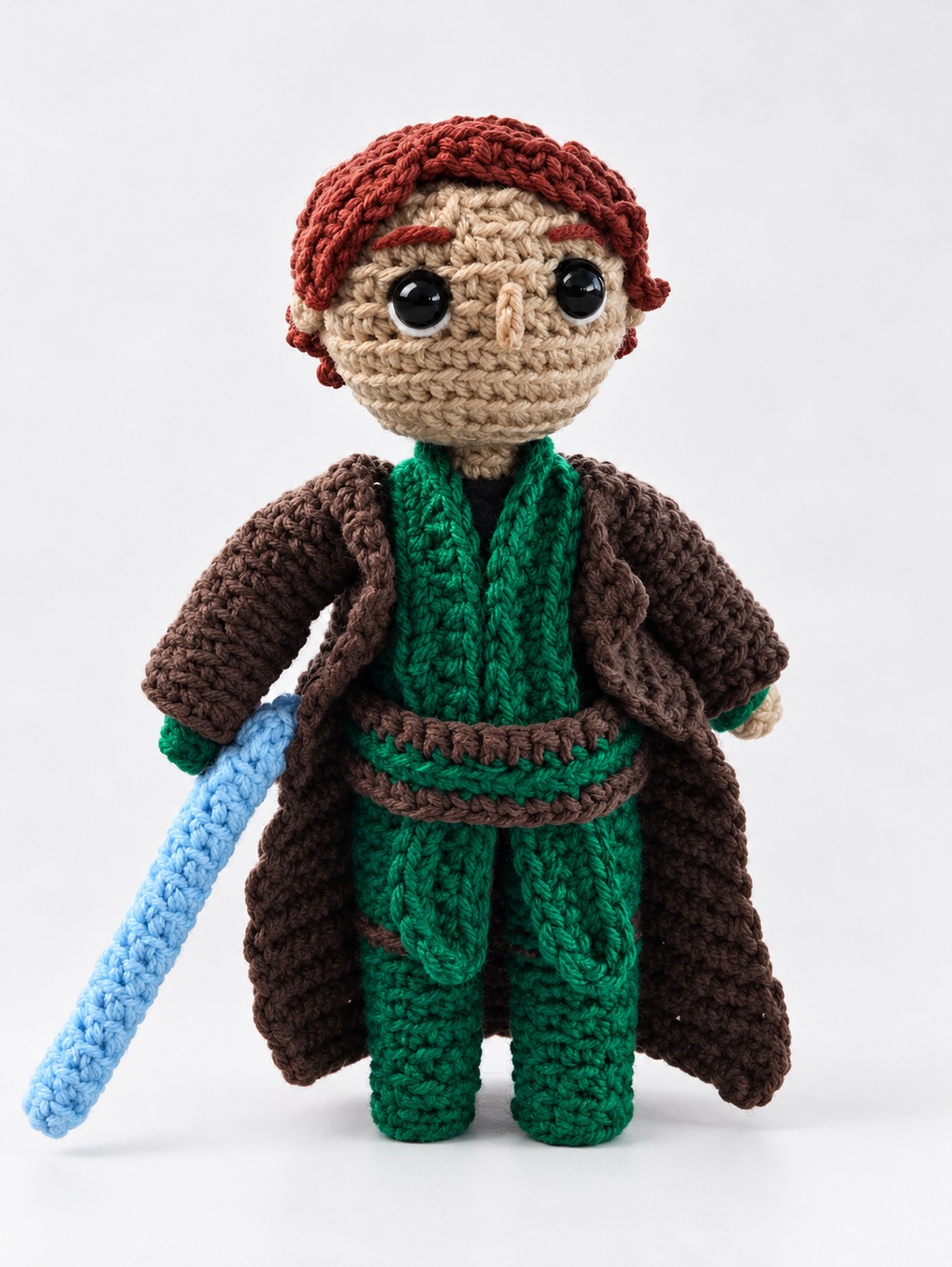 Red-haired crochet wizard character plushie with green scarf and blue wand