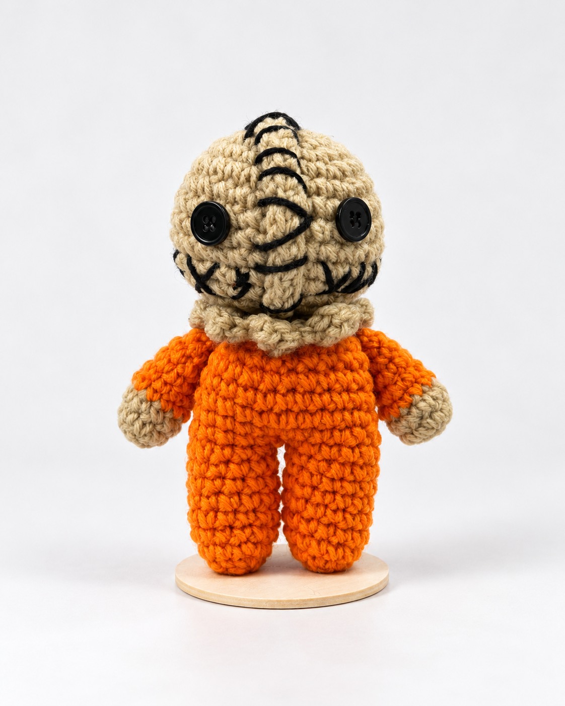 Stitched beige crochet character plushie in an orange jumpsuit
