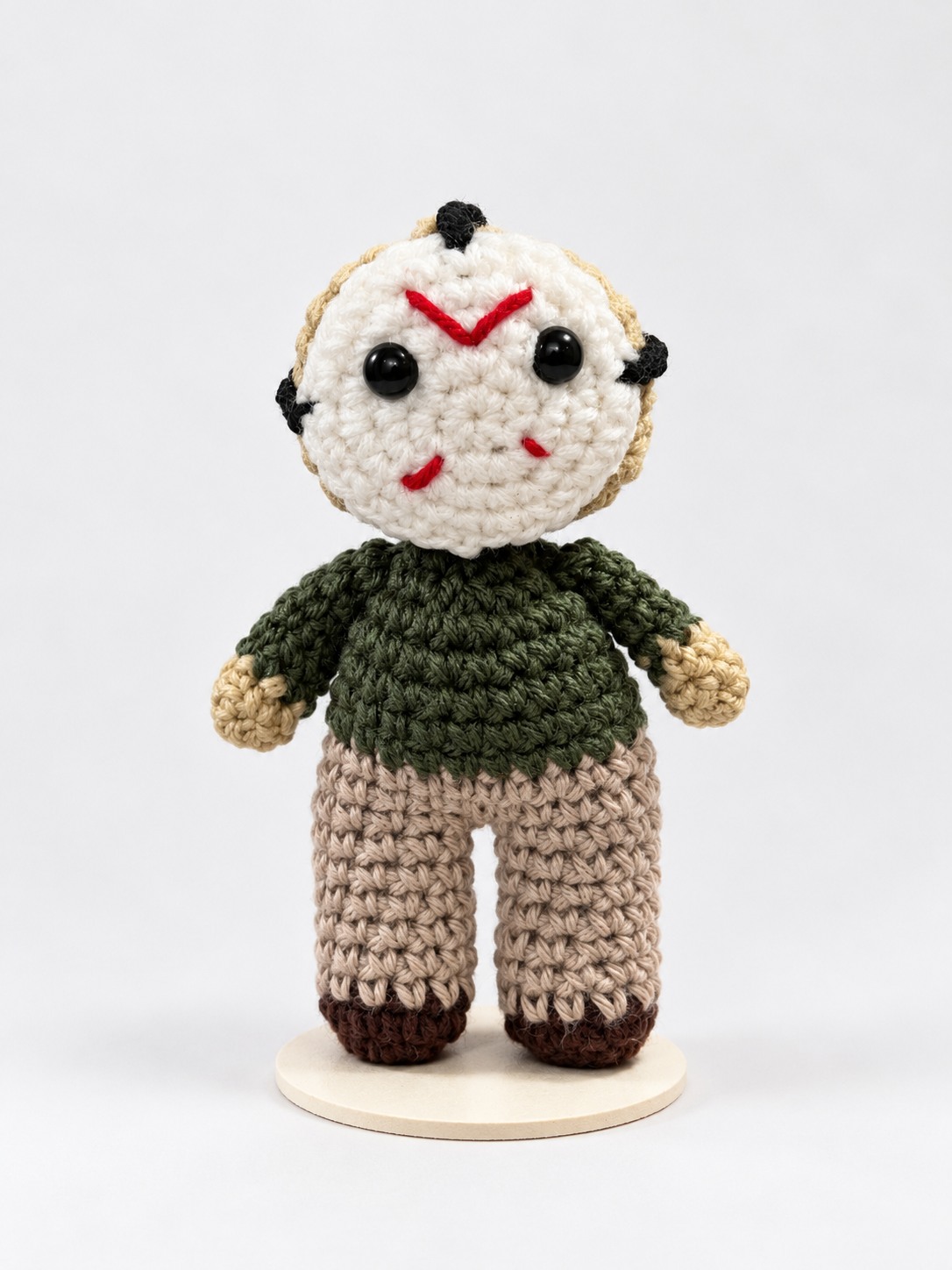 White mask crochet character plushie in a dark green sweater