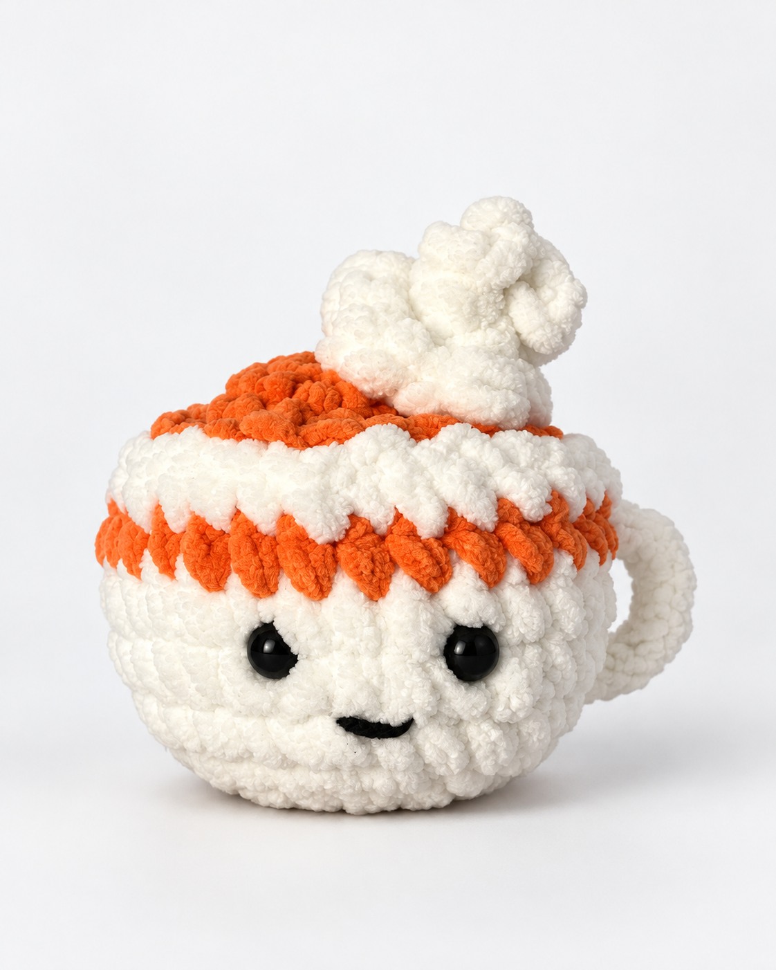 Cream and orange crochet cup plushie with a smiling face and whipped cream top