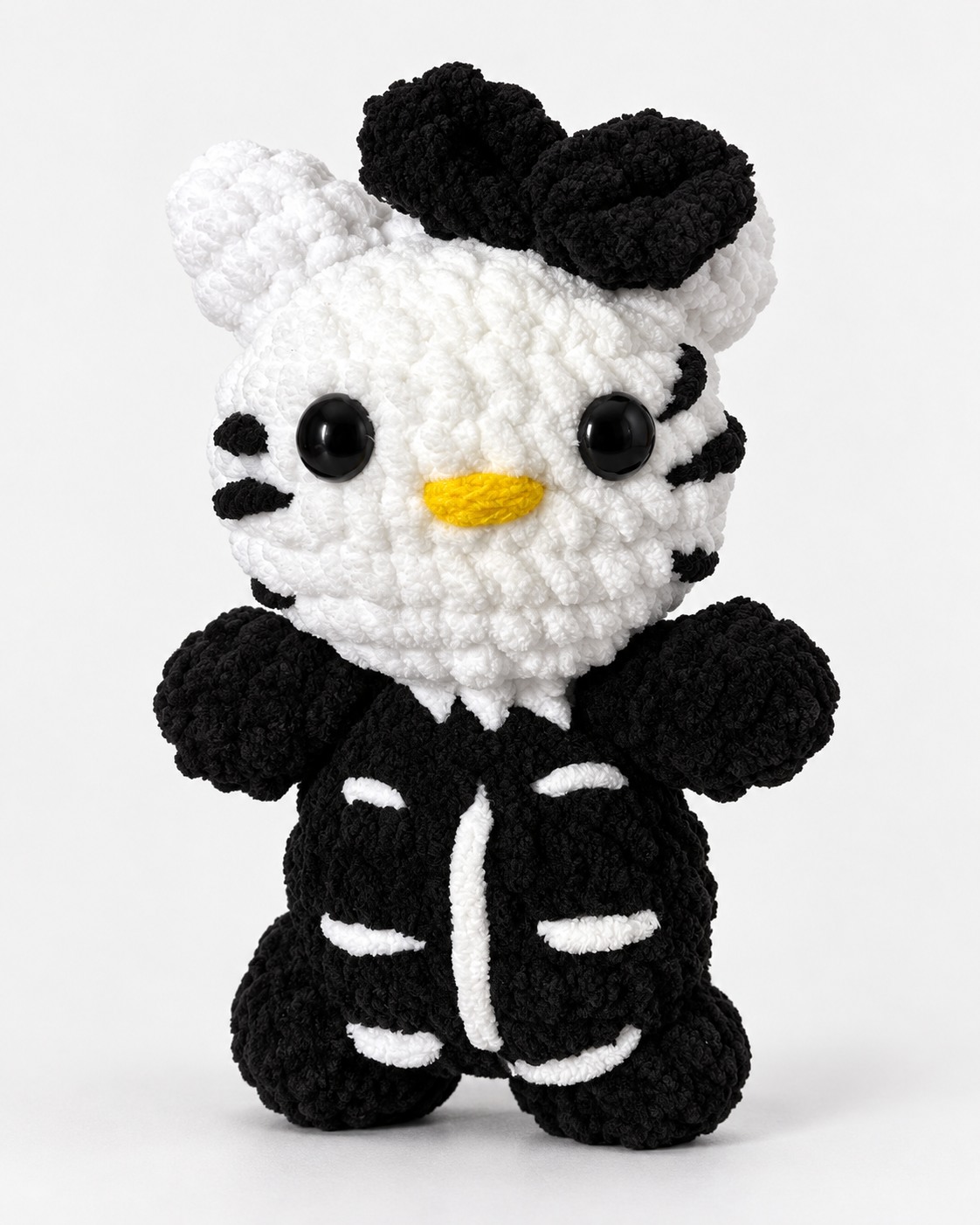 White crochet kitty with a black bow and black skeleton outfit