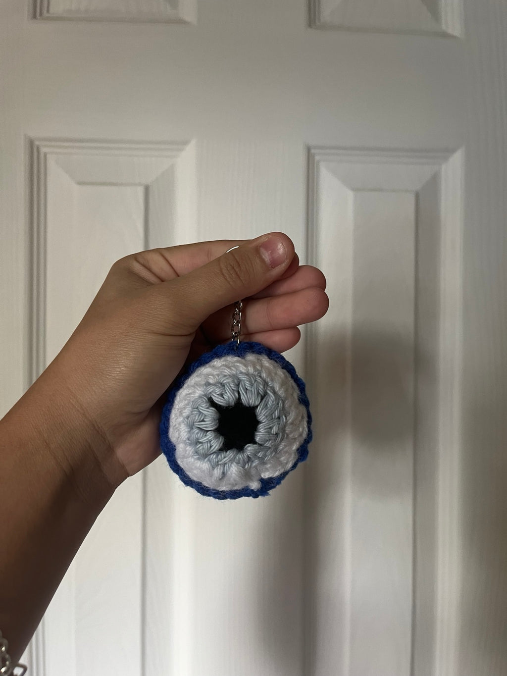 Blue, white and pale blue crochet eye keychain with a black center.