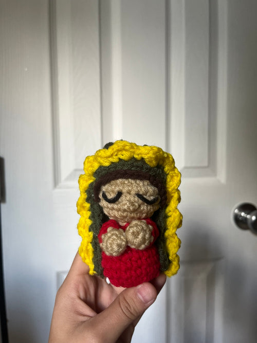 Crochet Guadalupe figure in red, with a green veil and yellow floral halo.